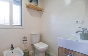 Bathroom features a toilet, bidet, and sink with mirror.