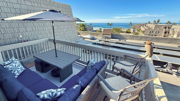 A rooftop terrace with a sofa set, a table, and a chair.