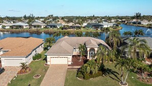 A residential area with houses, a lake, and palm trees. - Lakefront view with Pool & Spa, large Patio, close to Beaches and Shopping! Monthly Discount (Fort Myers)