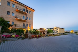 A multi-story building with balconies and a paved street in front.