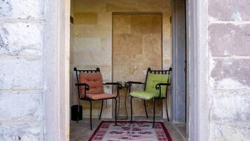 A narrow corridor with two chairs and a patterned rug.