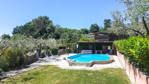 A backyard with a swimming pool, a covered seating area, and a small building. - Amazing apartment in Reggello with WiFi (Reggello)