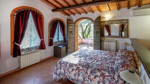 A bedroom with a bed, a dresser, a mirror, and a window with curtains. - Amazing apartment in Reggello with WiFi (Reggello)