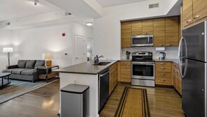 Een moderne keuken met houten kastjes, roestvrijstalen apparatuur en een centraal eiland.