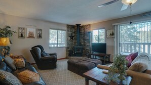 A cozy living room with a fireplace, leather furniture, and a TV.