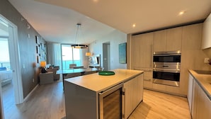 A modern kitchen with built-in appliances, a dining area with a view, and a spacious living area with a large window.
