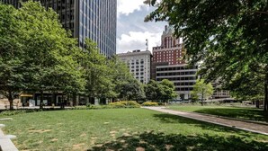 A park with a paved walkway, surrounded by trees and buildings. - One bedroom at Baltimore Covention Ctr (Baltimore)