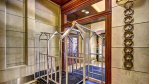 A hotel lobby with a metal elevator, a blue carpeted area, and a wall with circular decorations. - One bedroom at Baltimore Covention Ctr (Baltimore)