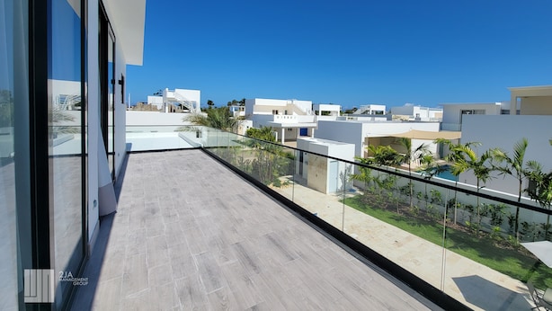 A modern building with a balcony overlooking a residential area. - Villa Marina (Sosúa)