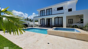 A modern two-story house with a swimming pool, outdoor seating, and a car parked in the driveway. - Villa Marina (Sosúa)