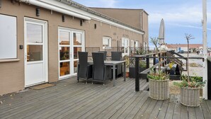 Un café avec une terrasse, une plateforme en bois et une vue sur la rue.