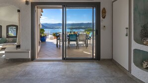 A room with a sliding glass door leading to a balcony with a view of the sea and mountains. - Villa Sallena by Interhome (Porto Vecchio)