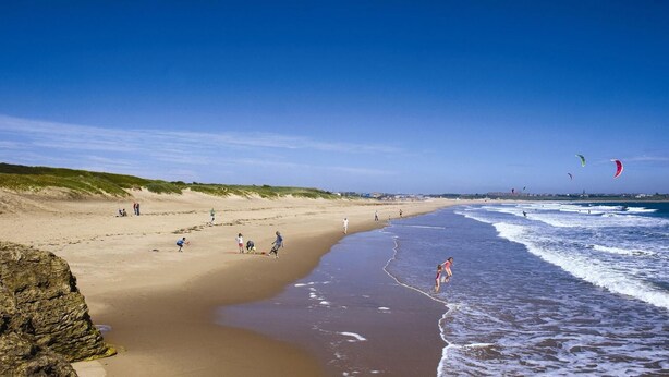 A beach with people walking and kite surfing. - 1 Bed Flat - Sleeps 3 - Parking - Pet friendly (South Shields)