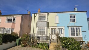 Una hilera de casas escalonadas con colores pastel característicos, una escalera central y un pequeño jardín.