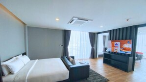 A modern hotel room with a large bed, a flat-screen TV, and a seating area. - BB hotel Savannakhet Laos (Savannakhet)