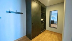 A hallway with a dark wooden wardrobe, a coat rack, and a mirror on the wall. - BB hotel Savannakhet Laos (Savannakhet)