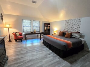 Une chambre à coucher avec un lit, un bureau, une chaise, une lampe et une bibliothèque.
