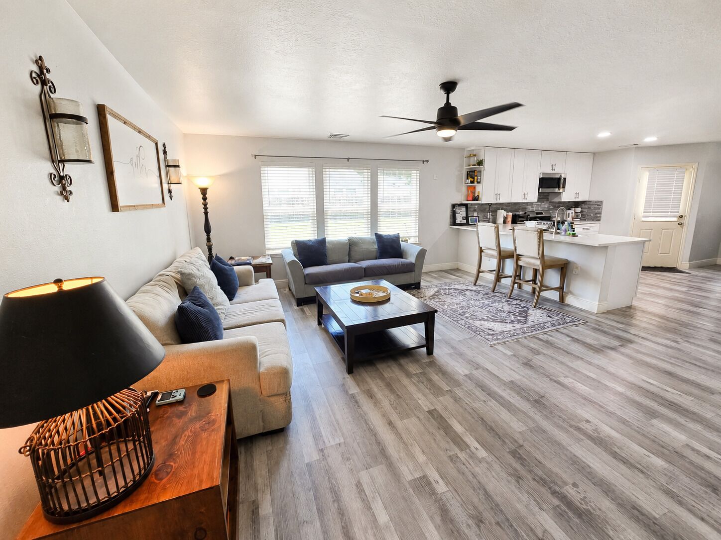 A modern living room with a sofa, coffee table, and a dining area with chairs.