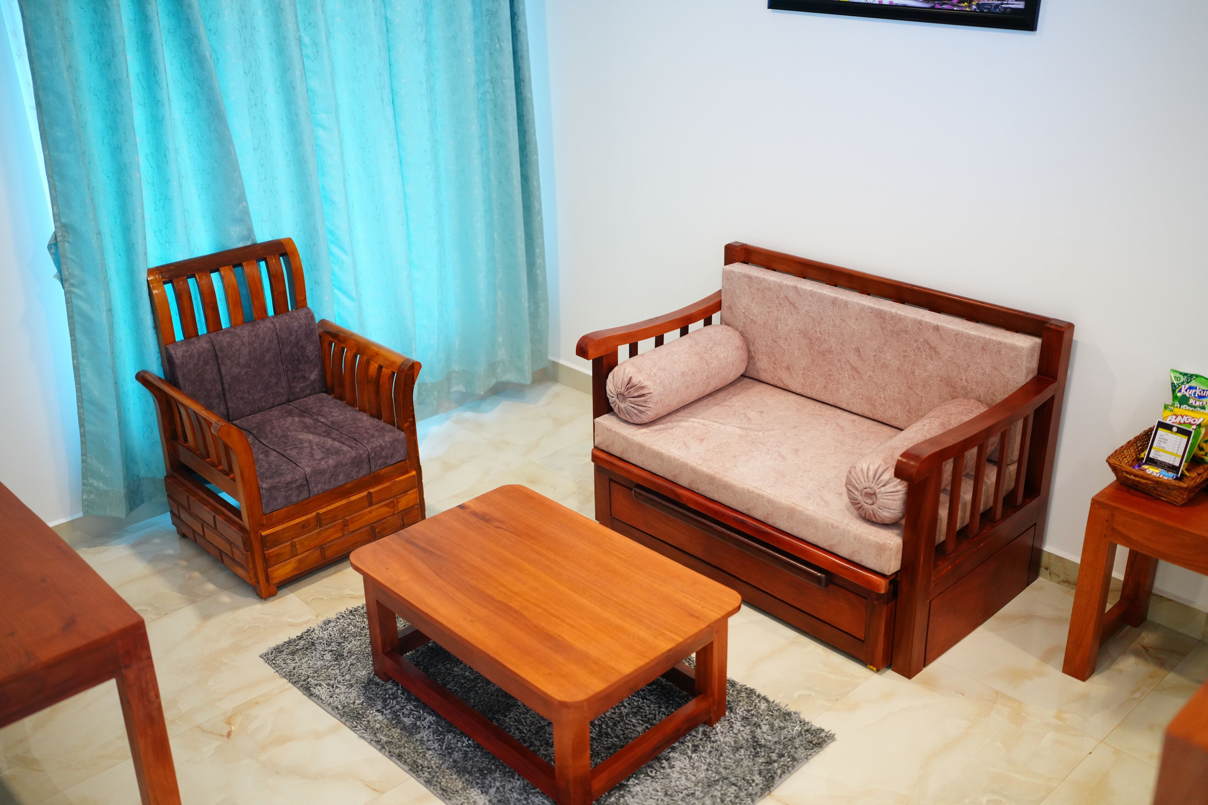 A living room with a wooden sofa, a wooden armchair, and a wooden coffee table.