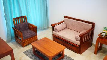 A living room with a wooden sofa, a wooden armchair, and a wooden coffee table.