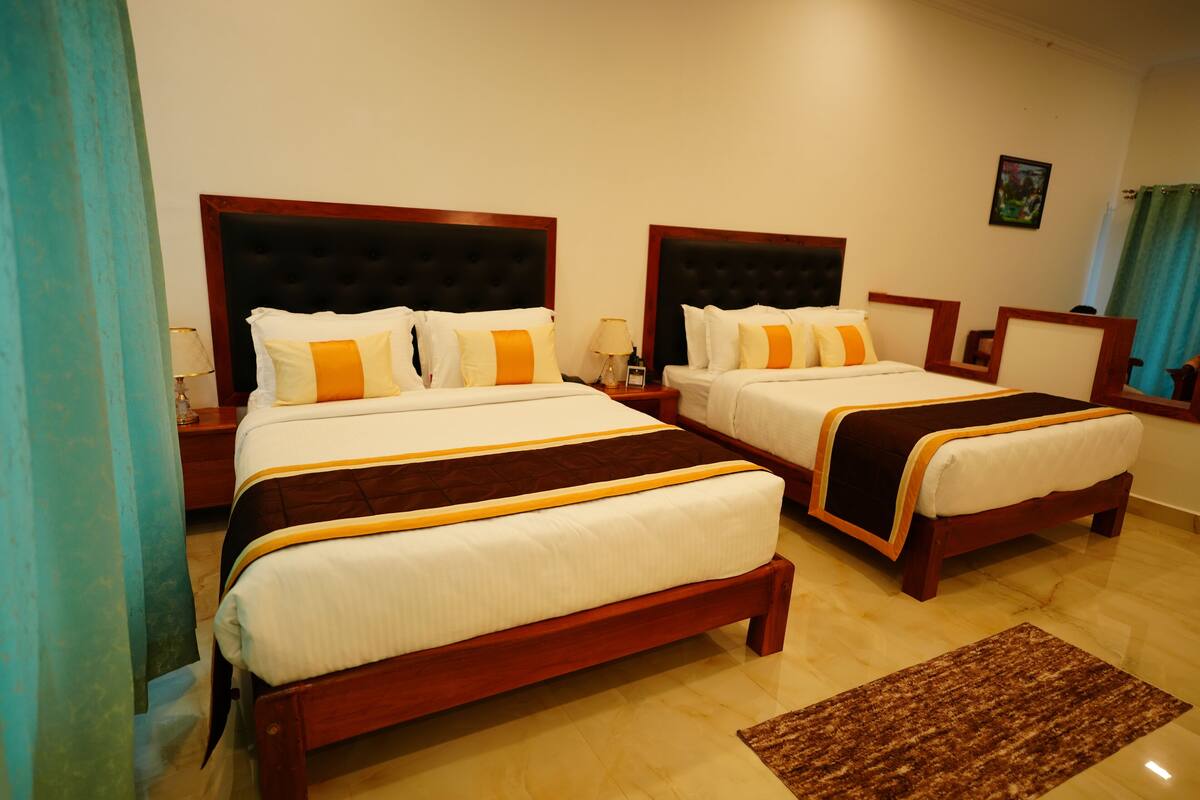 Een hotelkamer met twee bedden, elk met een houten hoofdbord, witte beddengoed en oranje accenten.