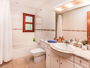 Une salle de bain équipée d’une baignoire, de toilettes, d’un lavabo et d’un meuble-lavabo.