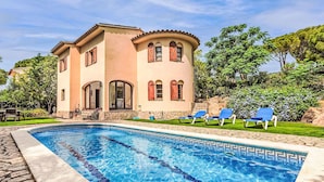 Une maison à deux étages avec une piscine à l’avant.