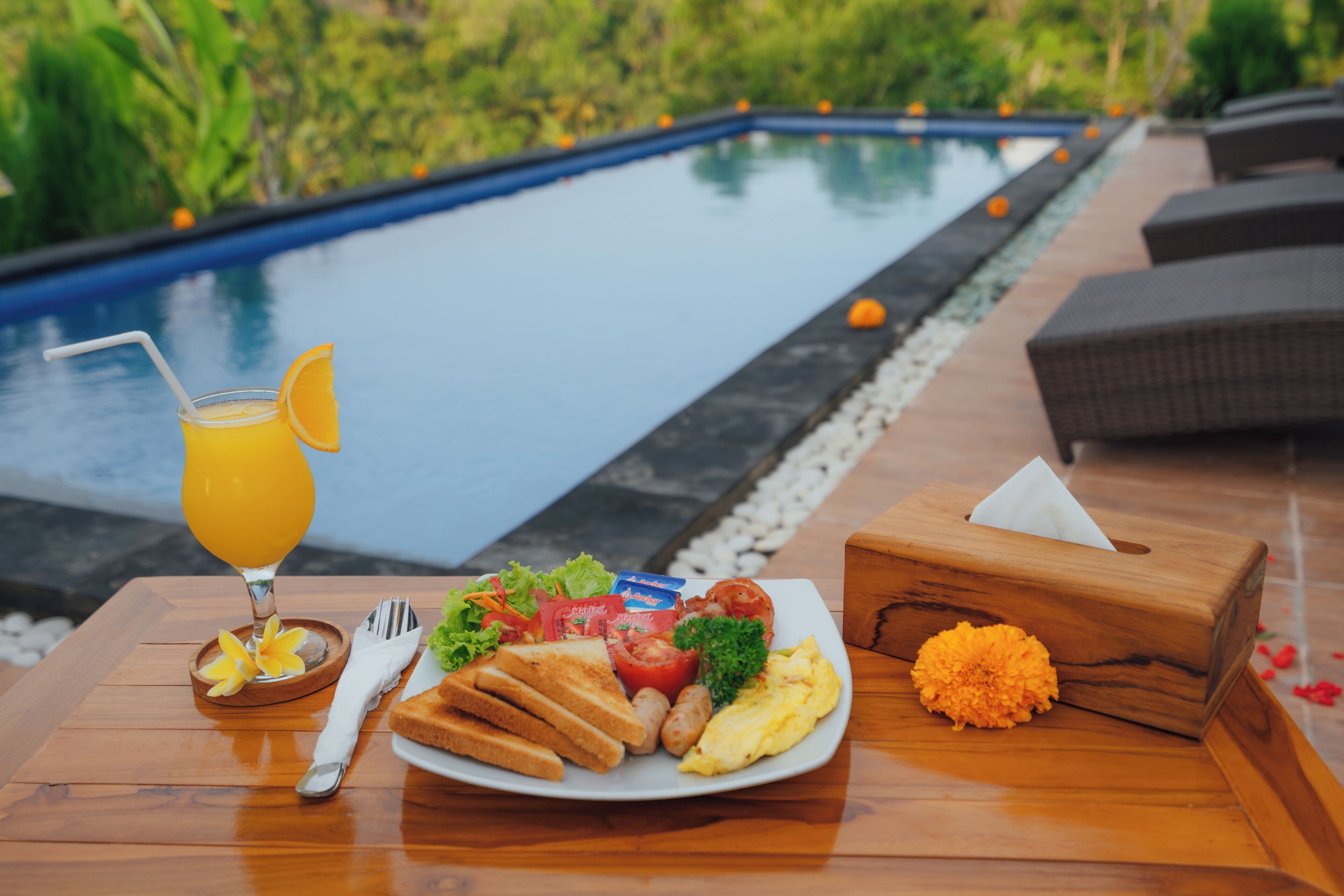 A breakfast table with a plate of food, a drink, and a napkin holder.