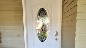 A white front door with a glass panel and a keypad lock.