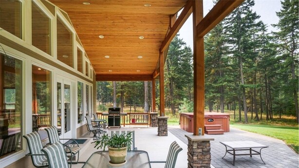Un patio couvert avec mobilier d’extérieur, un jacuzzi et un barbecue.