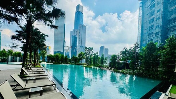 A swimming pool with lounge chairs and a view of tall buildings in the background. - Comfort Suite At Agile  (Kuala Lumpur)