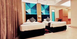 Ein Hotelzimmer mit zwei Betten, einem geometrischen Wanddesign und einem Spiegel.