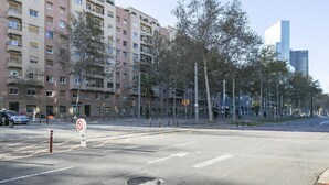 Un immeuble résidentiel à plusieurs étages, doté de balcons, d’un passage piéton et d’un feu de signalisation.