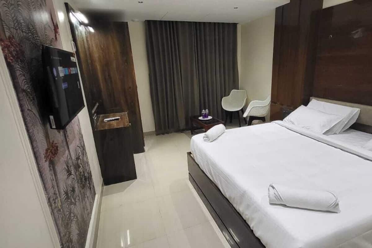 Une chambre d’hôtel avec un grand lit, une télévision, un bureau et une chaise.
