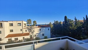 A residential building with a tiled roof, a balcony, and a view of the sea. - SAINT-AYGULF Sea view, 4 pers air conditioning, swimming pool, near Calanques corailleurs  (Fréjus)