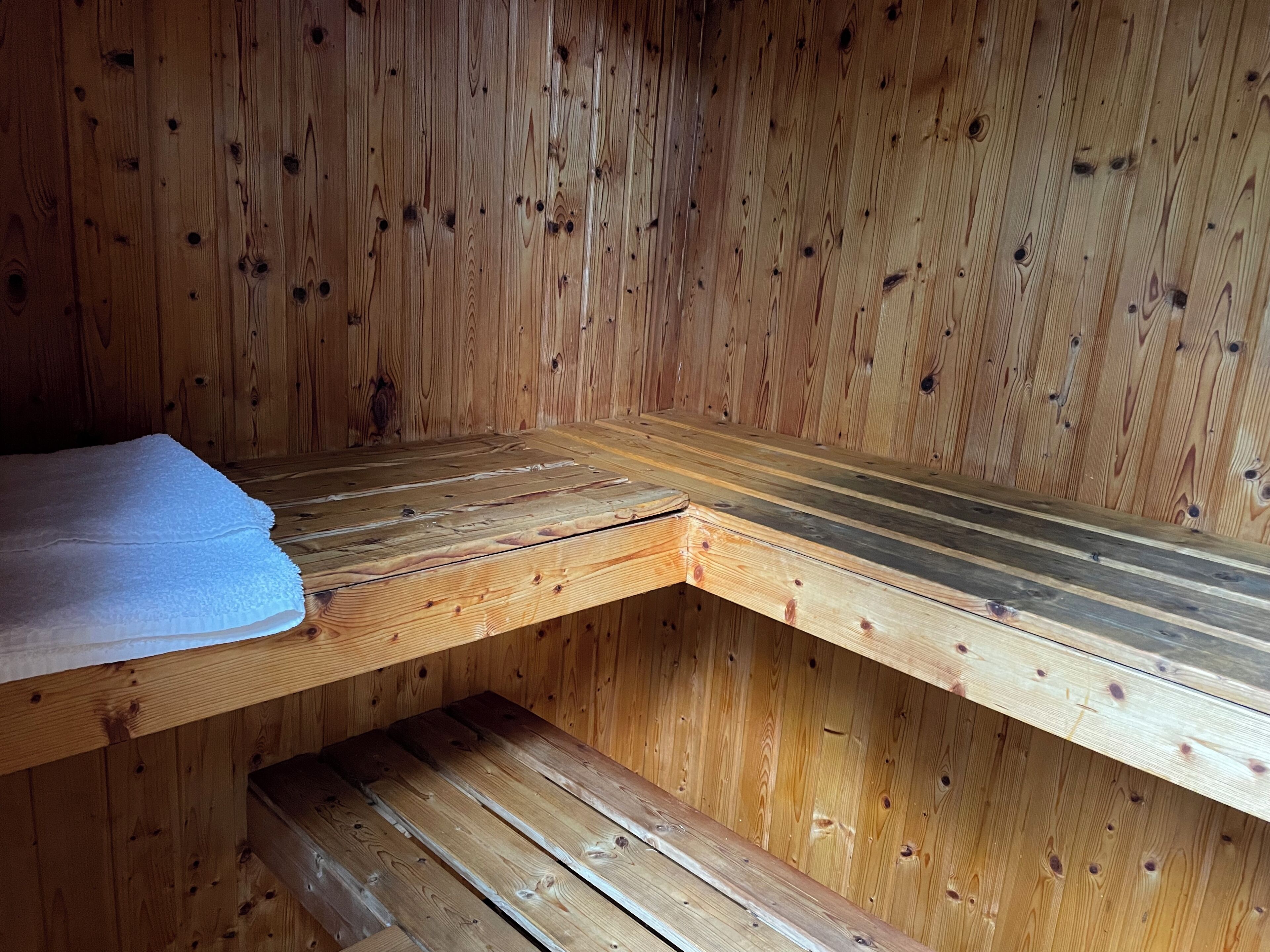 Una sauna de madera con bancos y un banco con una toalla.