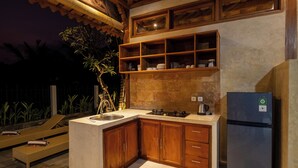 Eine Küche mit Holzschränken, einem Edelstahlkühlschrank und einer integrierten Regaleinheit.