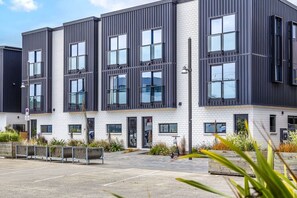 A modern multi-story building with large windows and a flat roof.