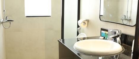 Un baño pequeño con inodoro, lavamanos, espejo y ducha.