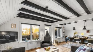A spacious loft with high ceilings, exposed beams, and large windows offering views of the outdoors. - "Sampo" - 150m to the fjord by Interhome (Tarm)