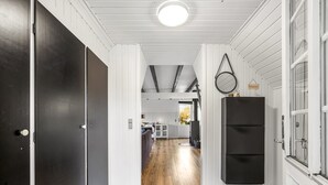 A hallway with wooden flooring, white walls, and a black door on the left. - "Sampo" - 150m to the fjord by Interhome (Tarm)