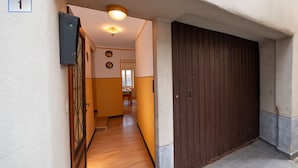 A hallway with a wooden floor, a brown door, and a number '1' sign on the wall. - Vacation home Ines by Interhome (San Bernardino)