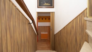 A wooden staircase with a handrail, leading to a room with a wooden door and a framed picture on the wall. - Vacation home Ines by Interhome (San Bernardino)