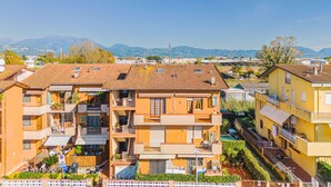 A multi-story residential building with balconies, a courtyard, and a view of distant mountains. - Menesini by Interhome (Viareggio)