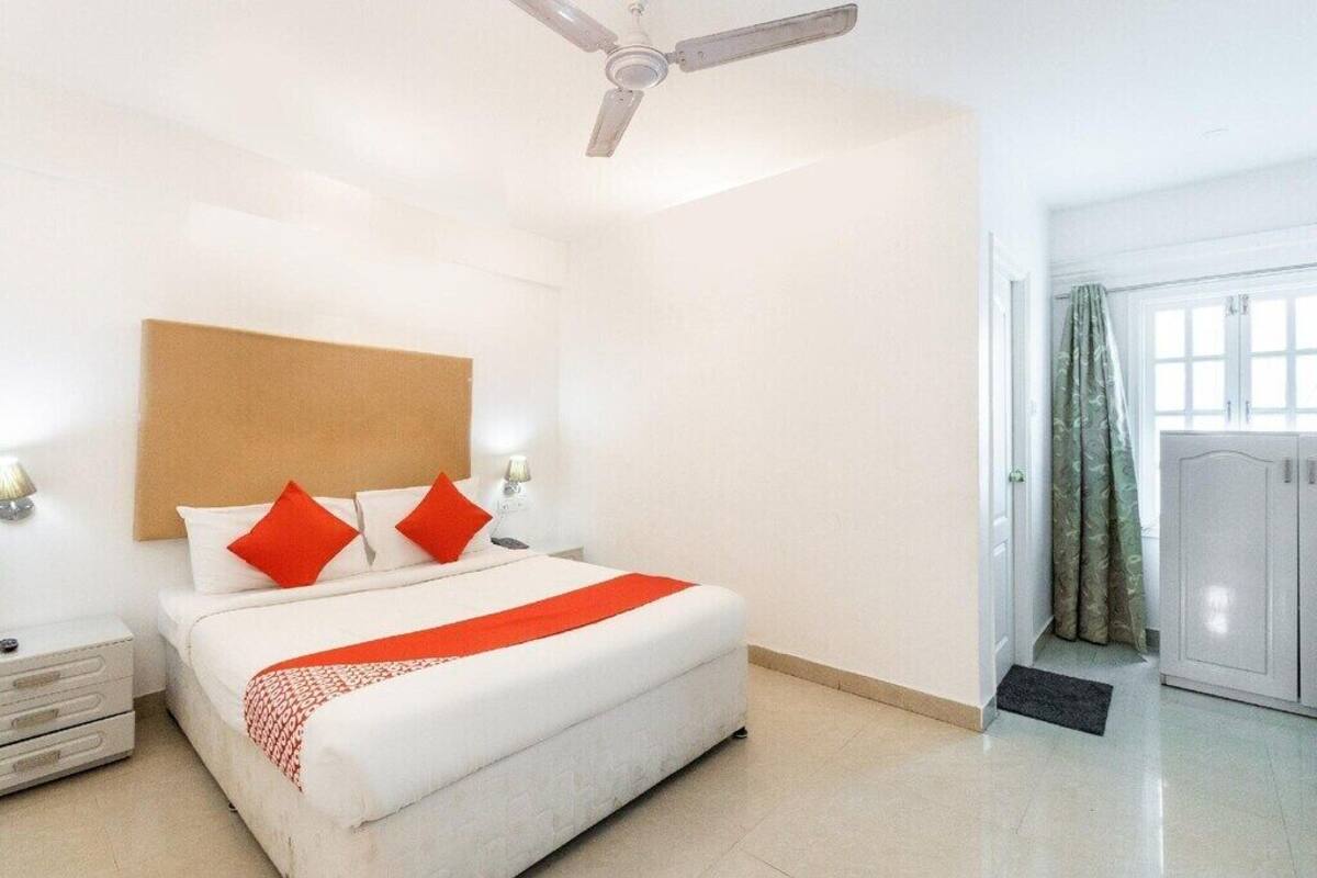 A hotel room with a bed, a nightstand, a wardrobe, and a ceiling fan.