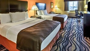 Una habitación de hotel con dos camas, un escritorio, una silla y un televisor.