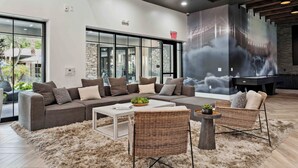 Ein modernes Wohnzimmer mit einer Eckcouch, einem Couchtisch und Korbstühlen.