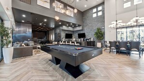 Ein geräumiger Wohnbereich mit Poolbillard, bequemen Sitzmöglichkeiten und modernen Leuchten.
