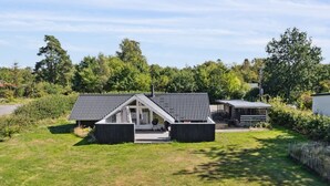 A modern house with a sloped roof, a covered porch, and a fenced yard. - "Janik" - 1.3km from the sea by Interhome (Græsted)