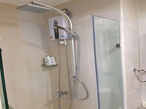 A shower area with a handheld showerhead, a glass-enclosed shower stall, and a shelf with toiletries. - Apex At Jazz Makati - 41m2 Corner Apartment With Private Balcony City View (Makati)